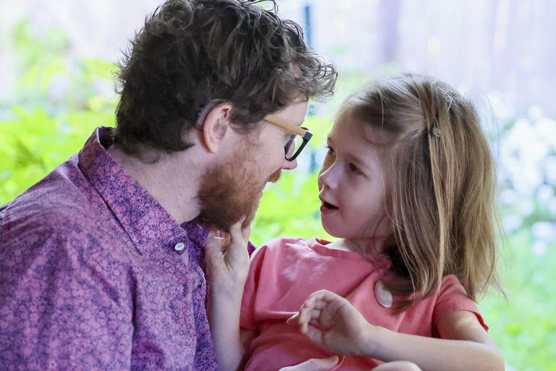 Patrick Conway, who is deaf, is trying to get one of his children, Luvi Balestracci, 5 and not deaf, into TOPS K-8, because its programs would allow him to fully participate in his child’s education.  (Kevin Clark / The Seattle Times)