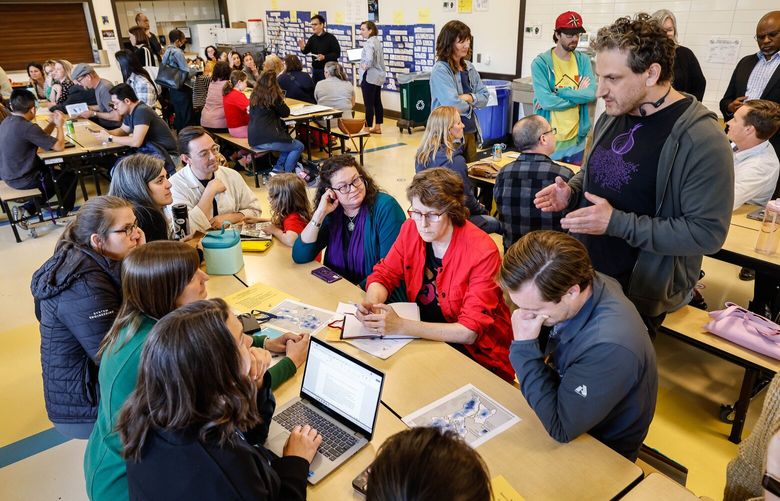 Concerned parents sit individually at tables staffed by Seattle School Board members to voice their concerns over enrollment policies Wednesday at Daniel Bagley Elementary School. 230048