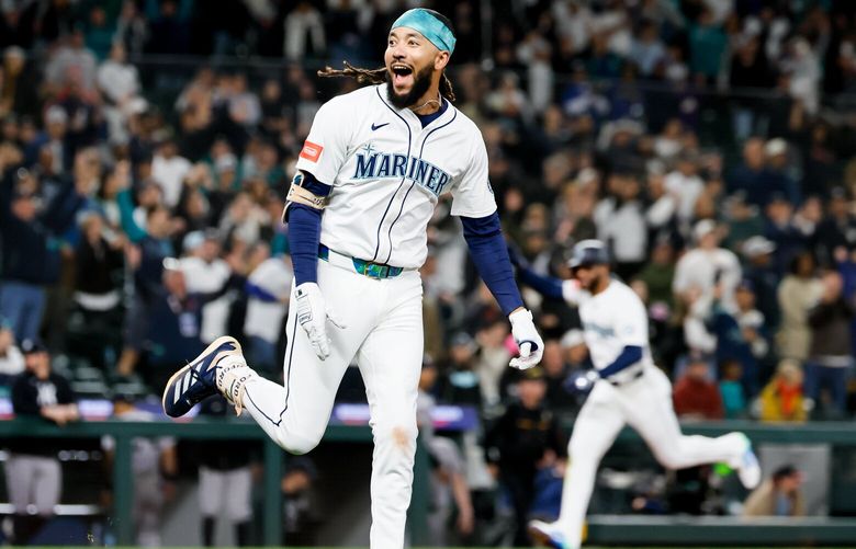 Seattle’s Leody Taveras, right, comes in to score the winning run on a RBI single by J.P. Crawford during the eleventh inning Tuesday, May 13, 2025 in Seattle. 230029