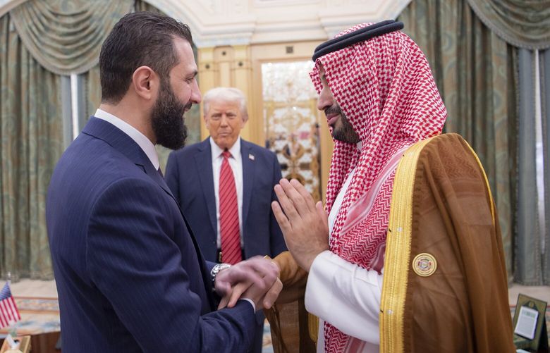In this photo released by the Saudi Royal Palace, President Donald Trump, centre, looks to Saudi’s Crown Prince Mohammed bin Salman, right, shake hands with Syria’s interim President Ahmad al-Sharaa, in Riyadh, Saudi Arabia, Wednesday, May 14, 2025. (Bandar Aljaloud/Saudi Royal Palace via AP) XHM104 XHM104
