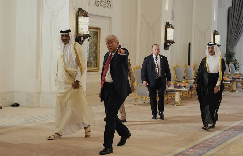 President Donald Trump gestures as he walks with Qatar’s Emir Sheikh Tamim bin Hamad Al Thani after a signing ceremony at the Amiri Diwan in Doha, Qatar, Wednesday, May 14, 2025. (AP Photo/Alex Brandon) HAS224 HAS224