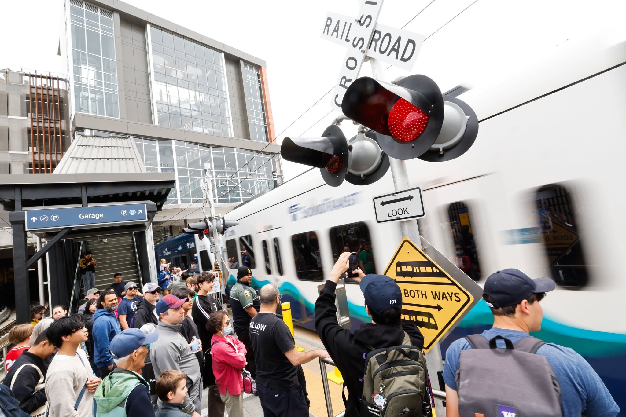 Crowds wait at the crosswalk at Marymoor Village Station on opening day of Sound Transit 2 Line extension between the Redmond Technology Station and Downtown Redmond Station on May 10. (Karen Ducey / The Seattle Times)