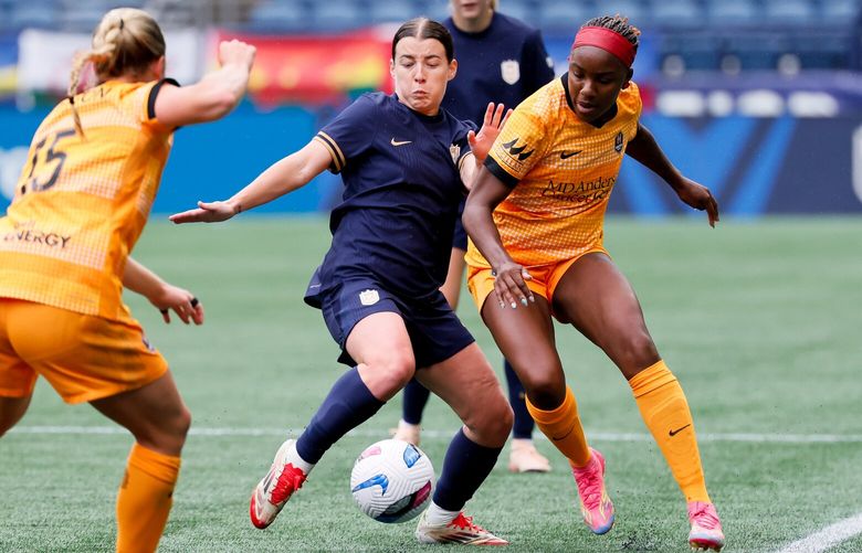 Seattle Reign FC midfielder Angharad James-Turner goes for the ball with Houston Dash forward Messiah Bright during the first half Sunday, May 11, 2025 in Seattle.