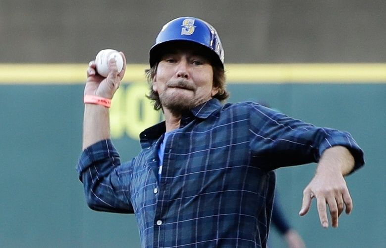 FILE- Pearl Jam singer Eddie Vedder throw out a ceremonial first pitch to Seattle Mariners’ Ichiro Suzuki before of a baseball game between the Seattle Mariners and the Chicago White Sox, July 20, 2018, at Safeco Field in Seattle. (AP Photo/Ted S. Warren, File)
