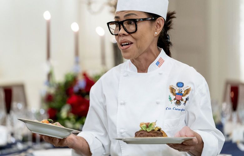 FILE – White House executive chef Cris Comerford, holds dishes as she speaks during a media preview for the State Dinner with President Joe Biden and French President Emmanuel Macron in the State Dining Room of the White House in Washington, Nov. 30, 2022. (AP Photo/Andrew Harnik, File) WX501 WX501