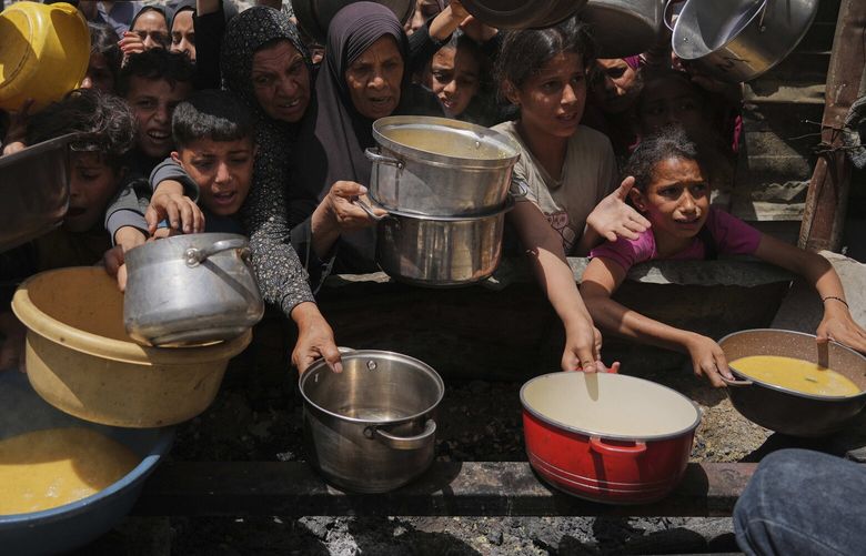 Palestinians struggle to get donated food at a community kitchen in Jabalia, northern Gaza Strip, Monday, May 19, 2025. (AP Photo/Jehad Alshrafi) XOB123 XOB123
