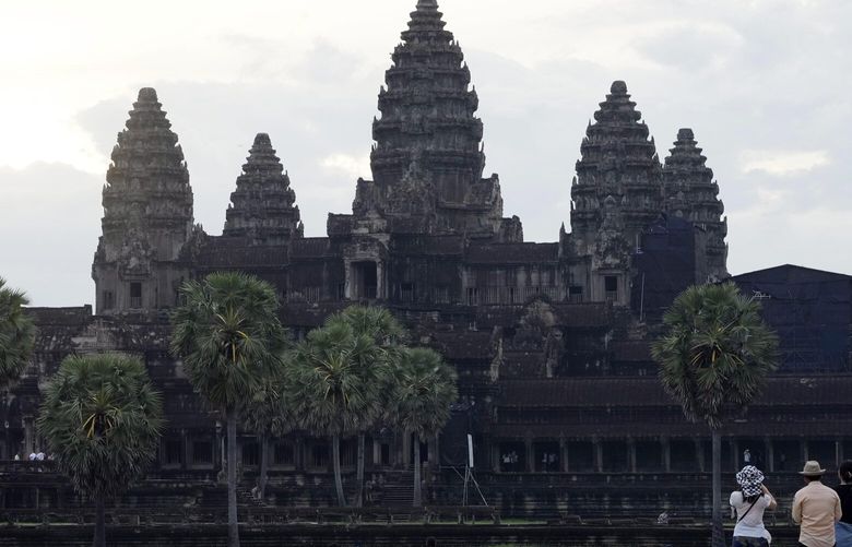 FILE – Tourists wait for sunrise at the Angkor Wat temple in Siem Reap province, Cambodia, Friday, Aug. 2, 2024.(AP Photo/Heng Sinith, File) TOK101 TOK101