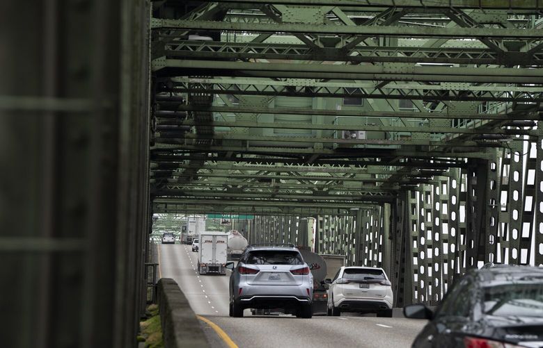 Traffic moves along the Interstate 5 bridge that spans the Columbia River and connects Portland, Ore., with southwest Washington state on Tuesday, Feb. 13, 2024. The bridge is set to be replaced as part of a multibillion-dollar project supported by federal funding. (AP Photo/Jenny Kane)