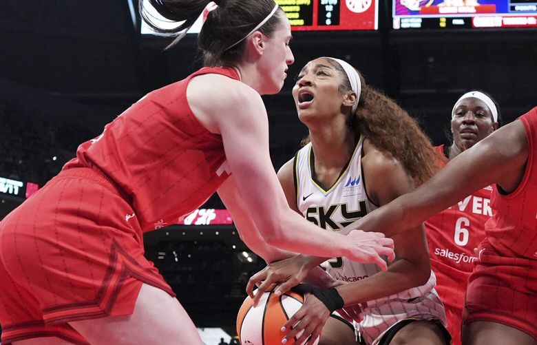 Indiana Fever guard Caitlin Clark, left, fouls Chicago Sky forward Angel Reese, center, during the second half an WNBA basketball game in Indianapolis, Saturday, May 17, 2025. (AP Photo/AJ Mast) INAM104 INAM104