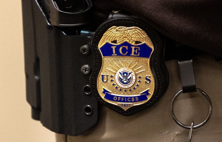 An ICE officer waits for a person outside of Seattle Immigration Court on Tuesday, May 20, 2025.