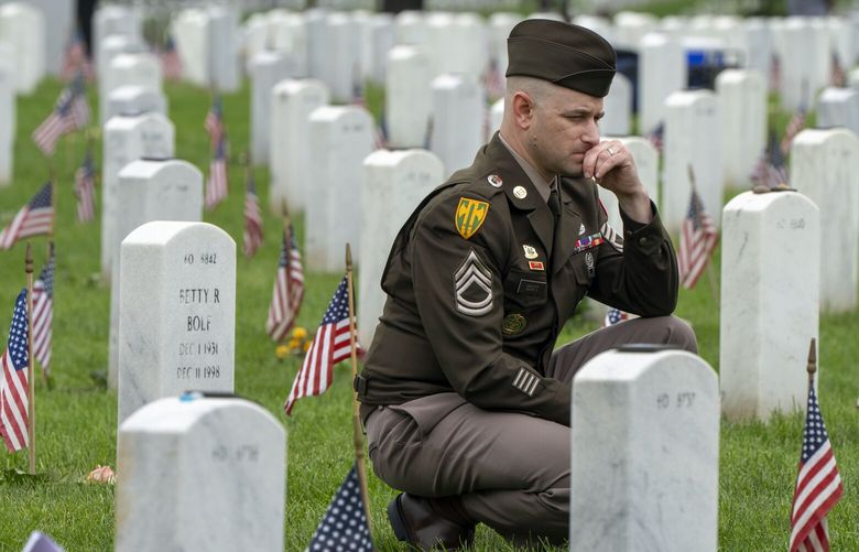 FILE – A member of the Army visits Section 60 of Arlington National Cemetery, in Arlington, Va., Monday, May 27, 2024, on Memorial Day. (AP Photo/Jacquelyn Martin, File) NY123 NY123