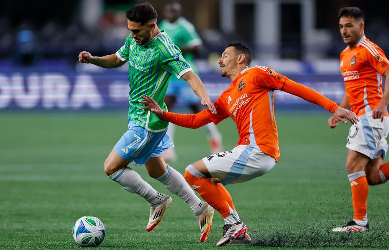 Houston Dynamo FC defender Daniel Steres tries to slow up Seattle Sounders FC midfielder Cristian Roldan as Roldan dribbles during the second half Saturday, March 22, 2025 in Seattle. 229563