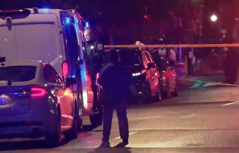 In this image taken from video provided by WJLA, a spectator watches as law enforcement works the scene after two staff members of the Israeli embassy in Washington were shot and killed outside the Capital Jewish Museum on Wednesday, May 21, 2025, in Washington. (WJLA via AP) DCTV302 DCTV302