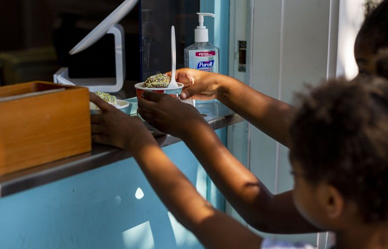 SEATTLE – HEAT WAVE – 062721
Alexis Mitchell Holt, 31, orders ice cream for herself and daughters Alaya, 6, and Averie, 4, at Molly Moon Ice Cream on Sunday, June 27, 2021 in Columbia City. Seattle hit two consecutive 100-degree days, the first time in record history on Sunday,