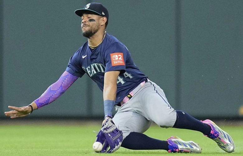 Seattle Mariners center fielder Julio Rodríguez tries to catch a single by Houston Astros’ Zach Dezenzo during the second inning of a baseball game Saturday, May 24, 2025, in Houston. (AP Photo/David J. Phillip) TXDP112 TXDP112