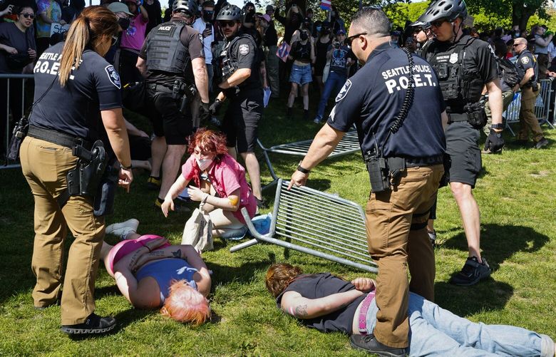 Seattle Police arrest protesters outside of the “Mayday USA Family Festival,” in Seattle’s Cal Anderson Park Saturday May 24, 2025. The Mayday USA festival is led by an evangelical Christian church and features live music, prayer, and conservative speakers.
