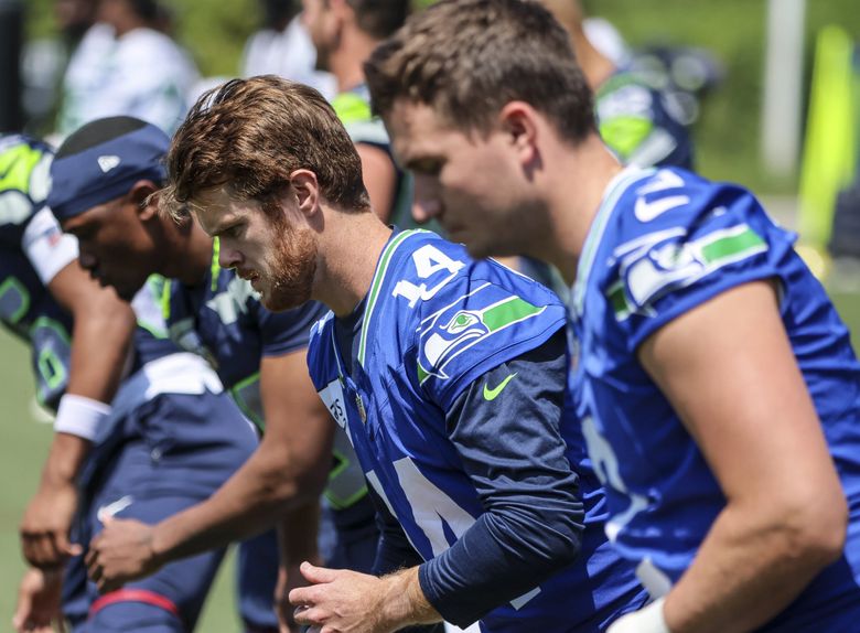 Seahawks QB Sam Darnold, center, stretches during OTAs on Monday in Renton. (Kevin Clark / The Seattle Times)
