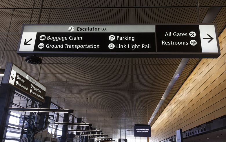 New signage at Seattle-Tacoma International Airport is in black and white because it is easier for passengers to see and read. The old, colorful signage will eventually be replaced. (Ellen M. Banner / The Seattle Times)