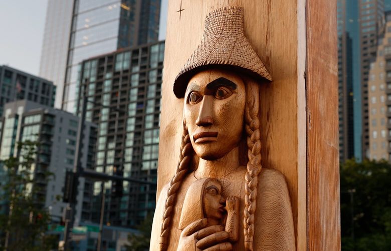 Looking at All Tomorrows, which translates to ??sla?lab?d k??di b??? dadatu in Suquamish, is a carving made by Randi Purser that represents Sholeesta, holding her son, the future Chief Seattle on the Seattle waterfront on Saturday, June 7, 2025. The post ia at the northernmost entrance of a series of post and beam structures designed by Oscar Tuazon that reference traditional longhouse architecture. These stretch across three blocks along the waterfront, spanning over the bike path, from Columbia Street to Spring Street.