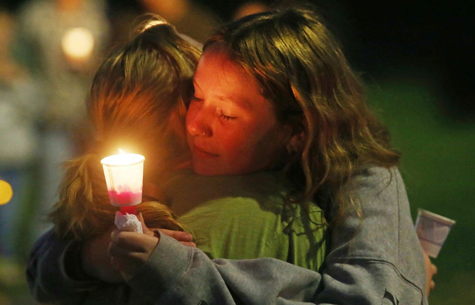 Wenatchee High School freshman Cora Belton, right, shares an embrace with Wenatchee High School senior Maya Scanlon during a vigil for Olivia Decker, 5, Evelyn Decker, 8, and Paityn Decker, 9, at Memorial Park Monday in Wenatchee. A missing person alert for the three young girls from Wenatchee was canceled Monday evening, though police say the investigation remains ongoing. The two know the Decker children through Short Shakespeareans of Wenatchee.