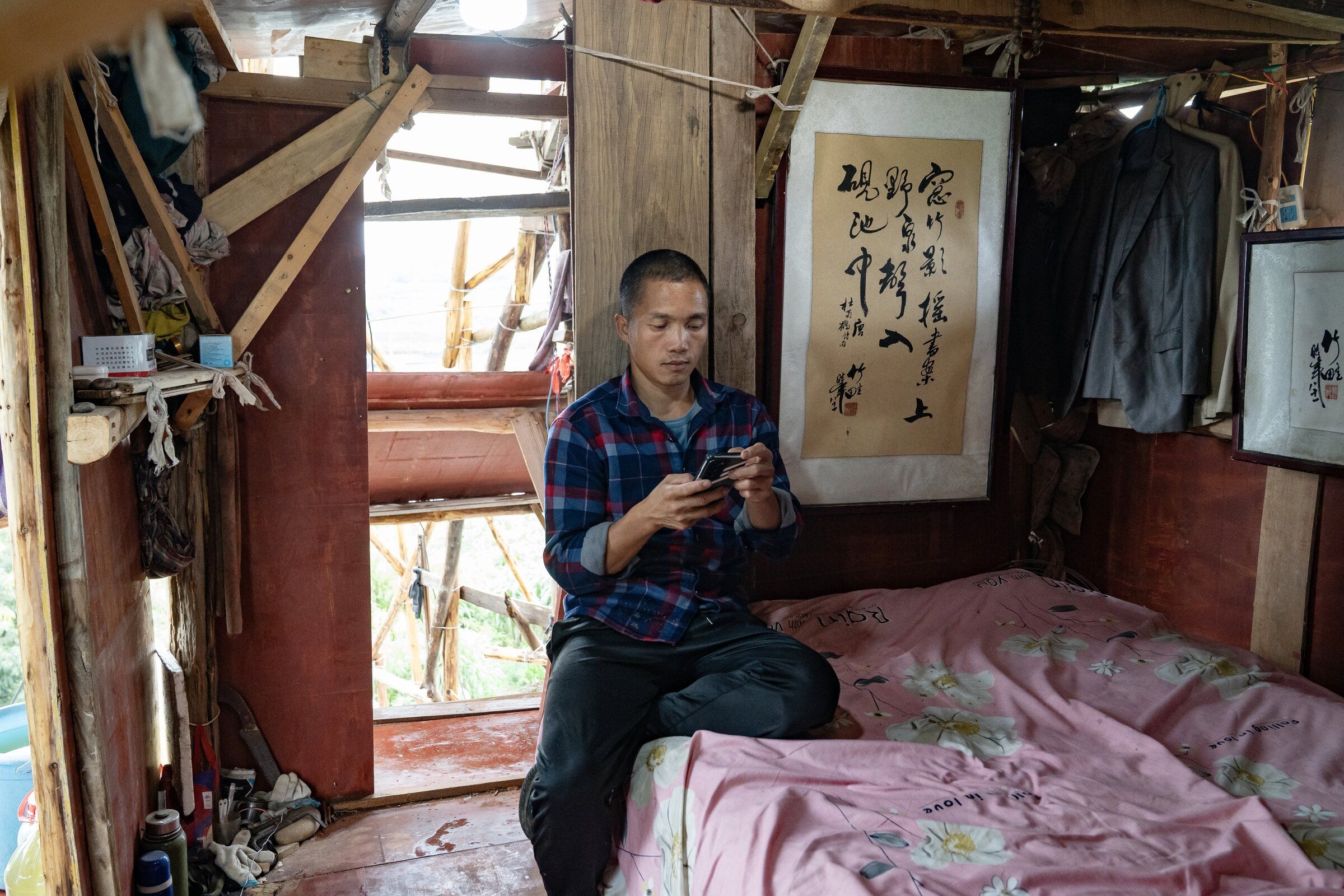 Chen Tianming looks at his phone in an upper floor bedroom of his house in Xingyi, China July 1. (Andrea Verdelli / The New York Times)