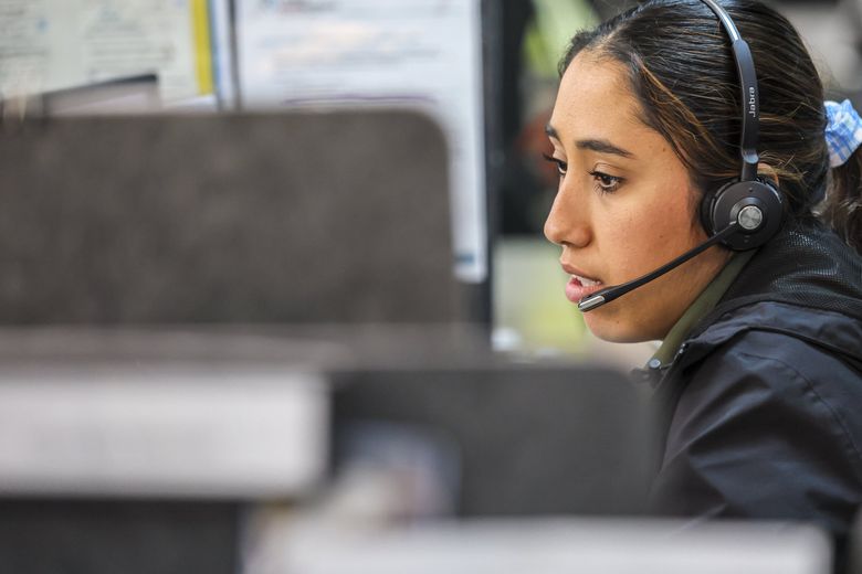 A worker at the Crisis Connections office in Seattle takes a call last month. (Kevin Clark / The Seattle Times)