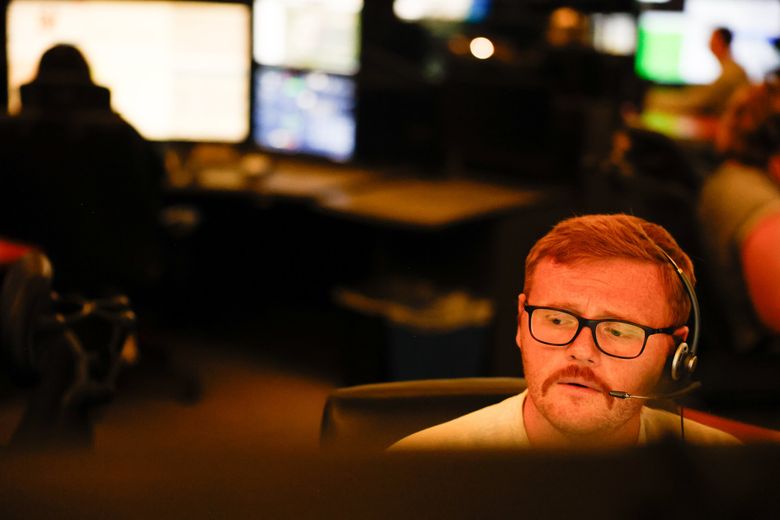 At the Valley Communications Center in Kent, Lucas Melville takes a call from someone who got in an accident. Valley Com is the regional 911 center that provides emergency communications services to communities in South King County. (Karen Ducey / The Seattle Times)