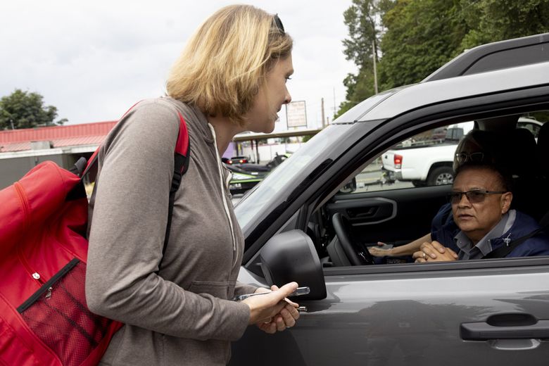 April Coberly, a case manager with Sound Behavioral Health’s mobile crisis team, speaks with crisis services director Joe Vela while responding to a situation in Auburn. (Akash Pamarthy / The Seattle Times)
