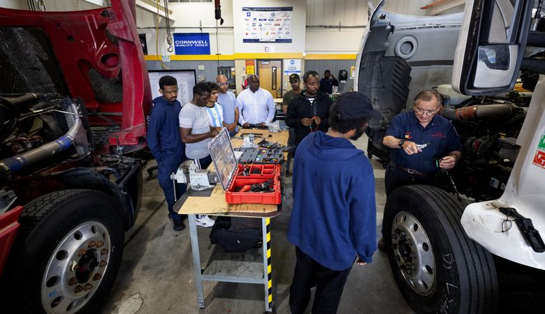 Diesel Transportation and Heavy Equipment Technology instructor Mark Murphy, right, teaches a class in July on electrical theory and how it relates to diesel engines at South Seattle College. (Ken Lambert / The Seattle Times)