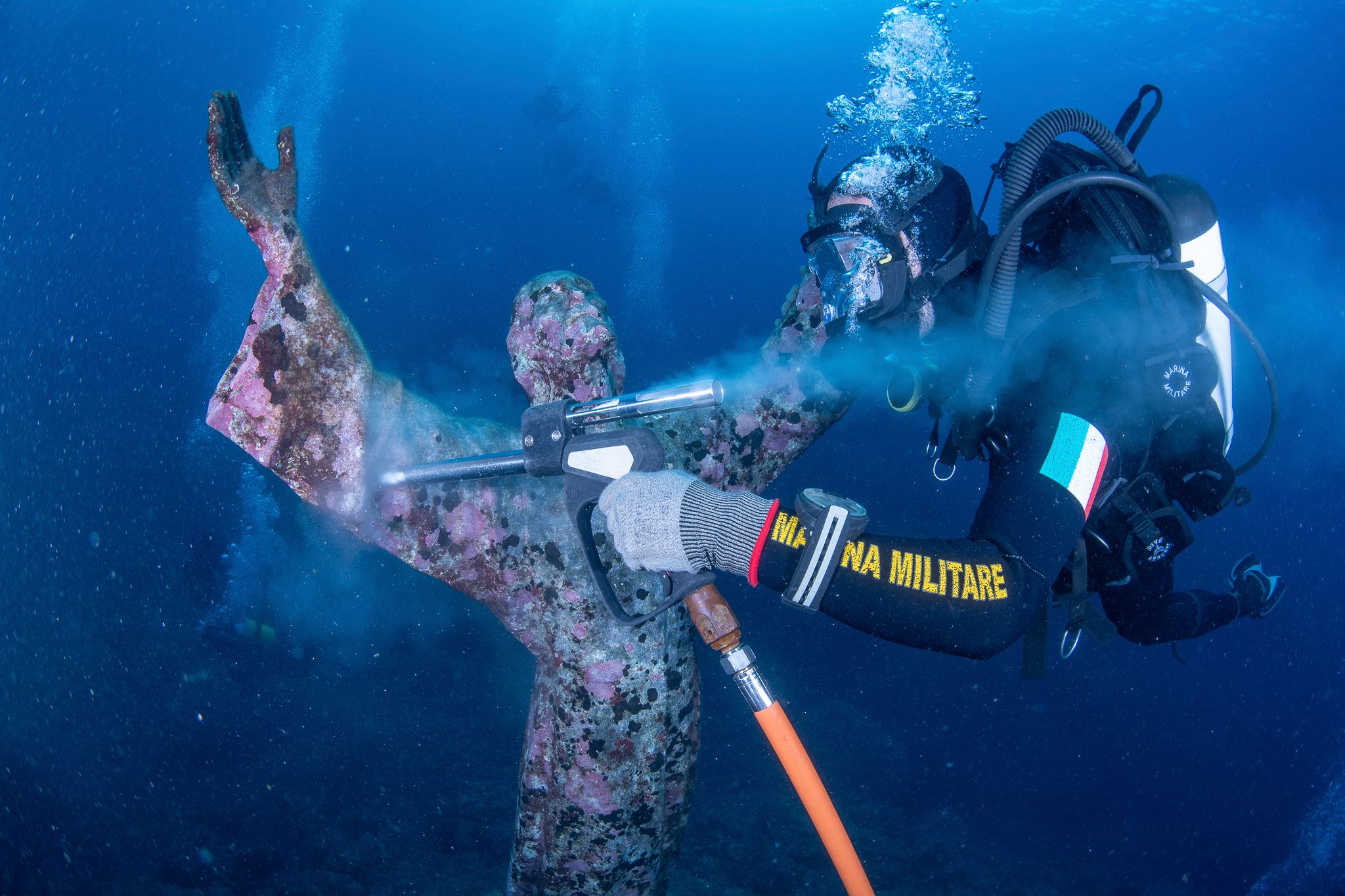 Italian divers water-blast the popular underwater statue of Christ