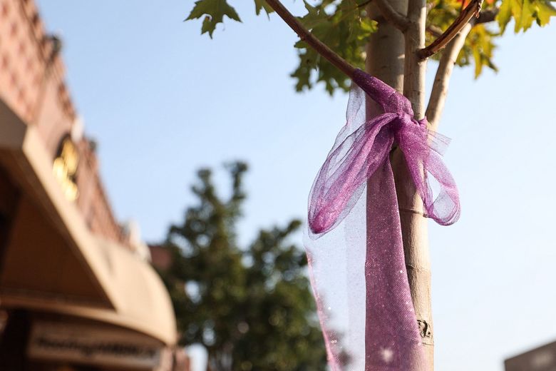 A ribbon is tied around a tree outside The Bloom Flowery in Wenatchee in memory of Evelyn Decker, Olivia Decker and Paityn Decker, who were found dead earlier this summer at a campsite near Leavenworth. (Nick Wagner / The Seattle Times)