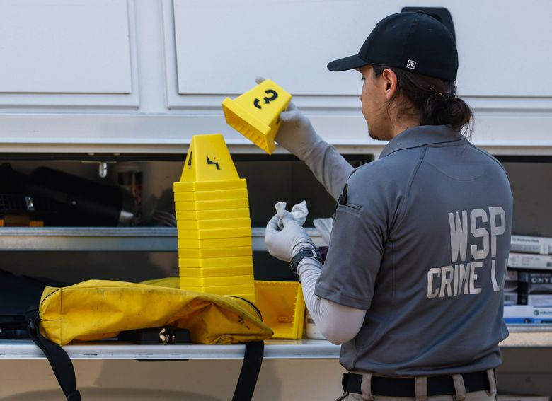 A worker from the Washington State Patrol Crime Lab cleans off evidence markers at the incident base for the Travis Decker investigation on Friday in Leavenworth. State Patrol spokesperson Chris Loftis anticipates the DNA testing of remains believed to be Decker’s is being expedited, and results could arrive next week. (Nick Wagner / The Seattle Times)