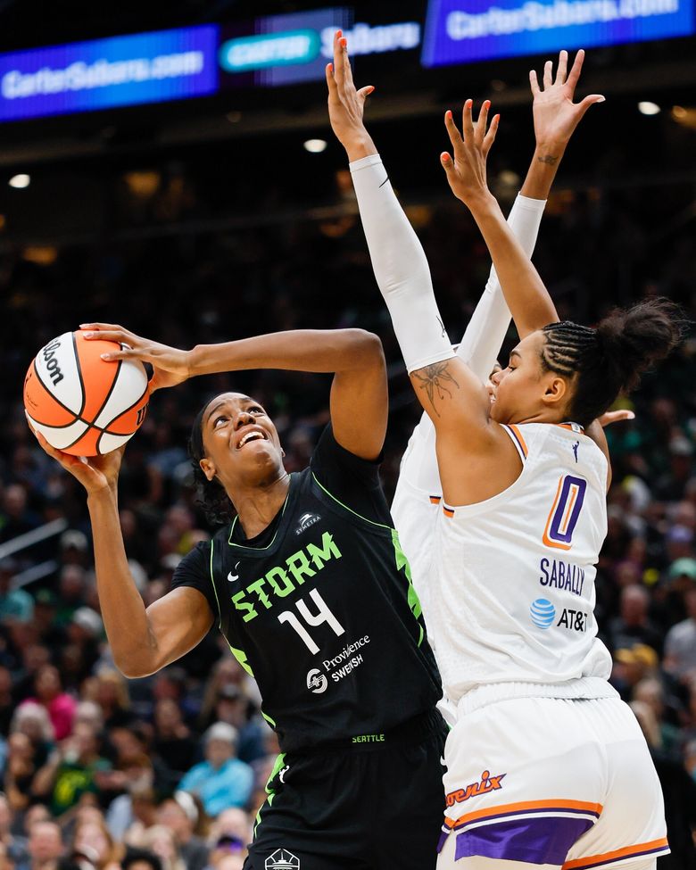 Trung phong Dominique Malonga của Seattle Storm nhìn chằm chằm vào rổ giữa hai cánh tay của tiền đạo Satou Sabally của Phoenix Mercury, ngày 17 tháng 8 năm 2025 tại Seattle. (Jennifer Buchanan / The Seattle Times)