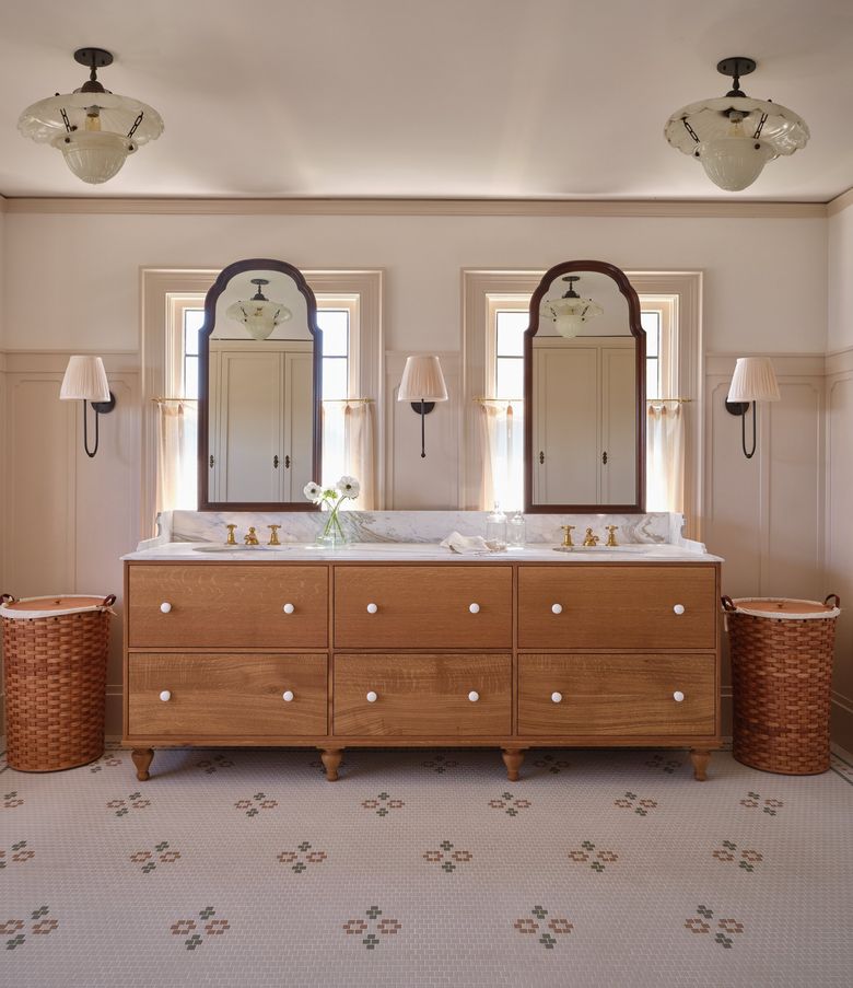 Placing mirrors over existing windows allowed the primary bathroom to accommodate a double vanity without changing the home’s exterior. (Michael Clifford)