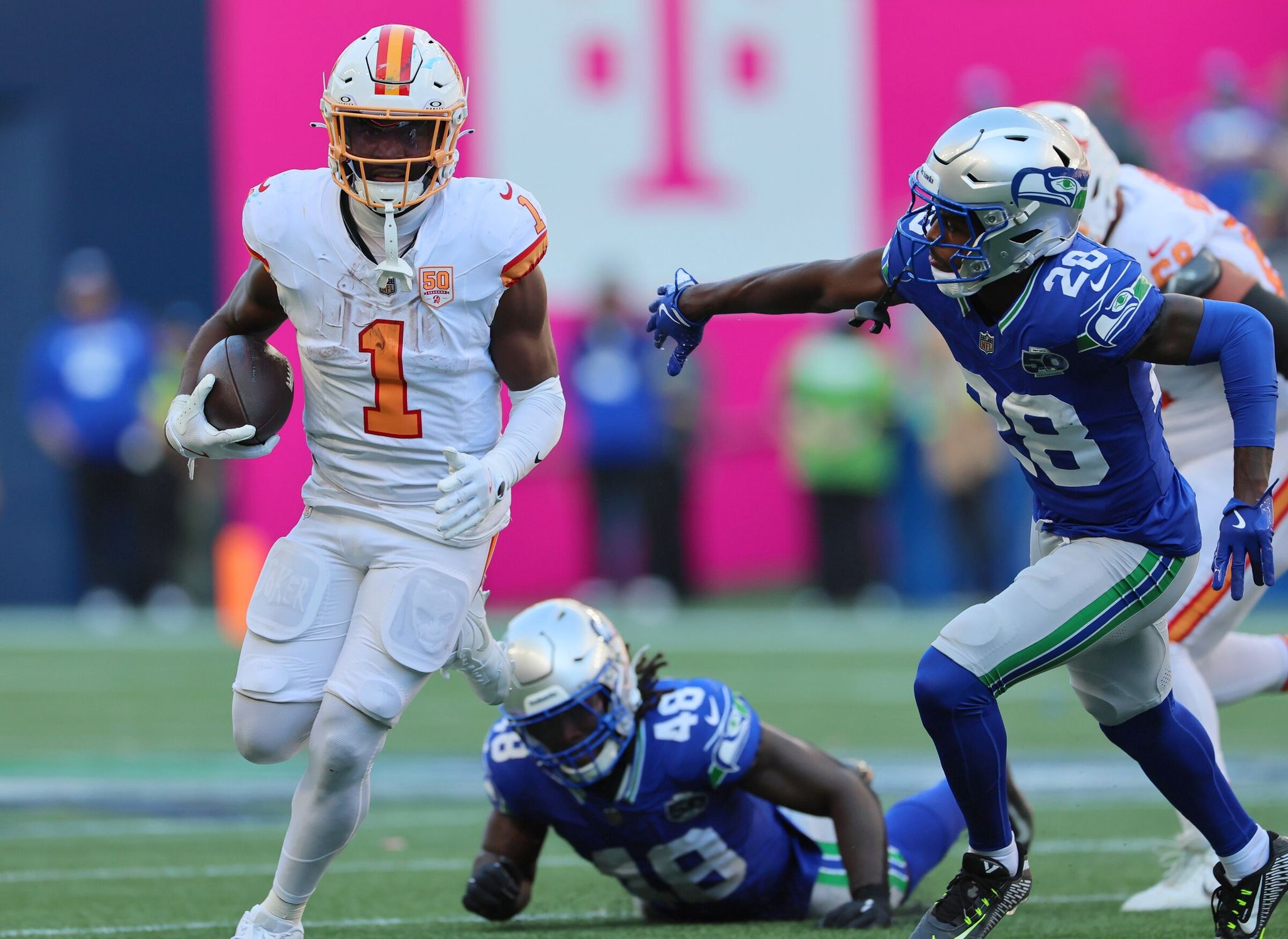 Рачаад Уайт, бегущий «Тампа-Бэй Бакканирс» (1), опережает защиту «Сиэтл Сихокс» в конце четвёртой четверти в воскресенье днём на стадионе Lumen Field. (Kevin Clark / The Seattle Times)