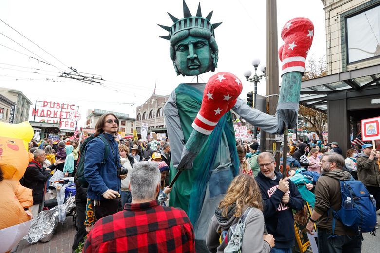Protesters carry a Statue of Liberty puppet with boxing gloves near Pike Place Market as the &#8220;No Kings&#8221; march came to an end in Seattle on Saturday. (Karen Ducey / The Seattle Times)