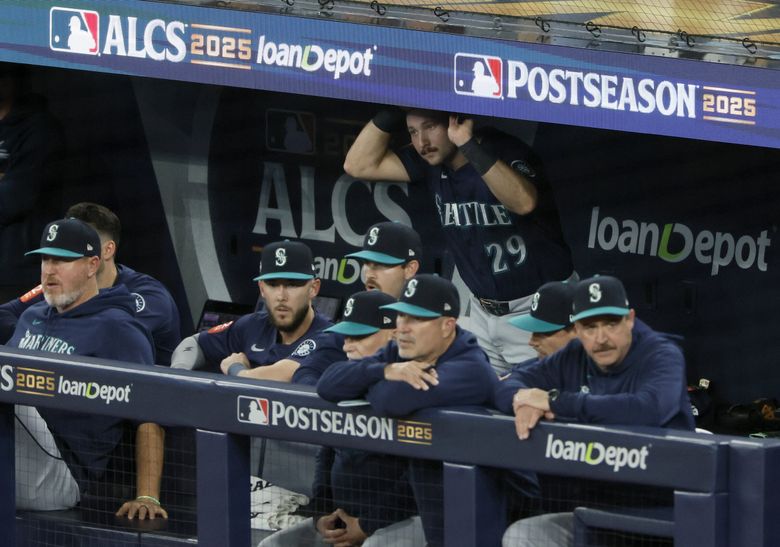 Seattle Mariners catcher Cal Raleigh peeks out of the dugout in the 8th inning against the Toronto Blue Jays in game 7 of the American League Championship Series on Monday, Oct. 20, 2025 in Toronto.  (Jennifer Buchanan / The Seattle Times)