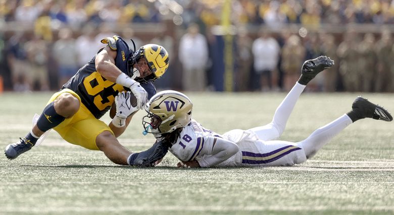 Washington safety Rylon Dillard-Allen tackles Michigan tight end Zack Marshall during a college football game, Oct. 18, 2025, in Ann Arbor, Mich. (Nick Wagner / The Seattle Times)
