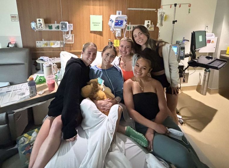 From left to right, UW soccer players Lucy Newlin, Mia Hamant, Kelsey Branson, Kolo Suliafu and gymnast Olivia Oppegard smile during a visit to Hamant’s hospital room at UW Medical Center earlier this year. Courtesy of Kevin Hamant / University of Washington)
