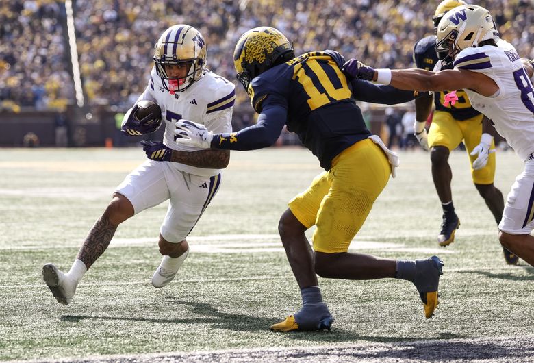 Washington Huskies wide receiver Raiden Vines-Bright (7) runs with the ball as Michigan Wolverines defensive back Zeke Berry (10) closes in during a college football game on Saturday, Oct. 18, 2025, in Ann Arbor, Mich. (Nick Wagner / The Seattle Times)