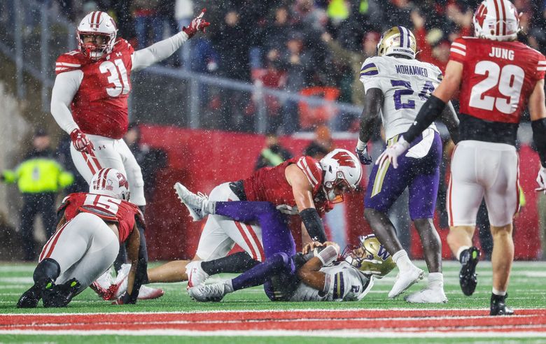 Demond Williams Jr. is dropped well short of the first down marker, effectively ending any chance of coming back against Wisconsin on Saturday. (Dean Rutz / The Seattle Times)
