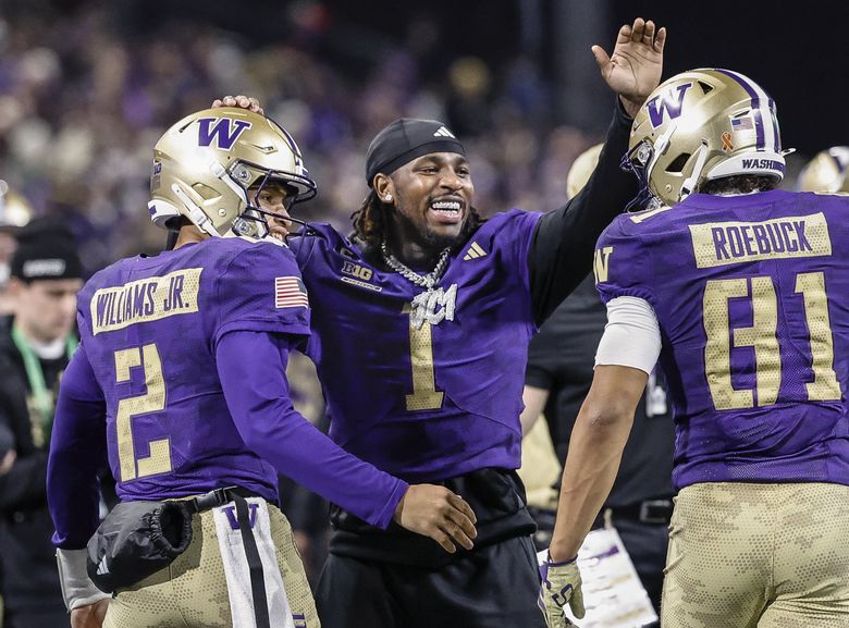 Jonah Coleman congratulates Demond Williams Jr., left, and Dezmen Roebuck after they connected for a two-yard touchdown in the third quarter, Nov. 15, 2025 at Husky Stadium, in Seattle. (Dean Rutz / The Seattle Times)