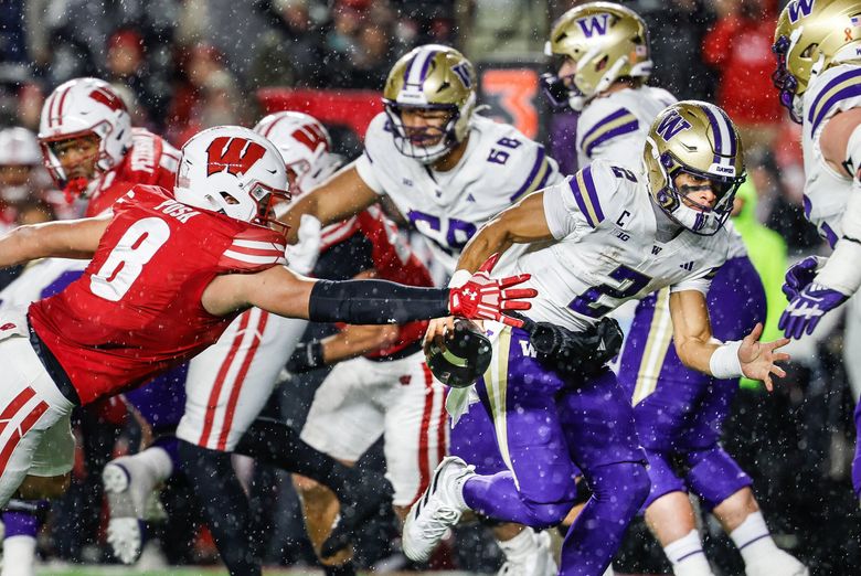 Wisconsin linebacker Mason Posa gets a hand on the ball as Washington quarterback Demond Williams Jr. scrambles, and forces a fumble that the Badgers would recover on Saturday. (Dean Rutz / The Seattle Times)