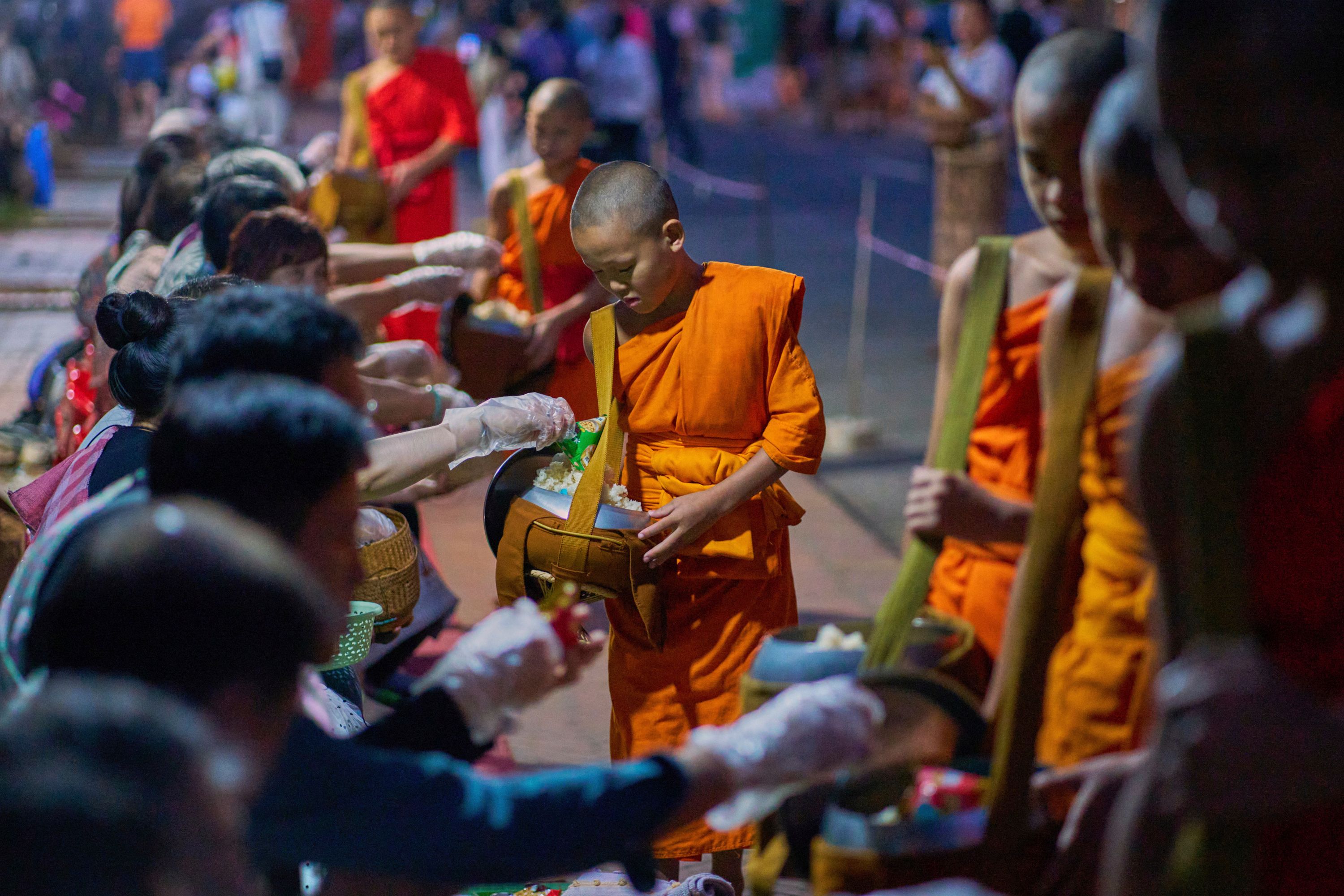 Photos of Buddhist monks in Laos praying in region littered with