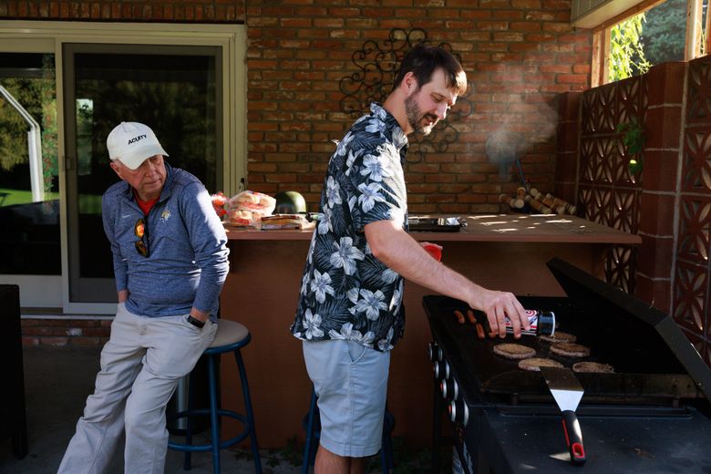 Columbus Mayor Webb Mandeville, left, and state Sen. Forrest Mandeville, his son, grill for a birthday party at Forrest’s home in Columbus. (Erika Schultz / The Seattle Times)
