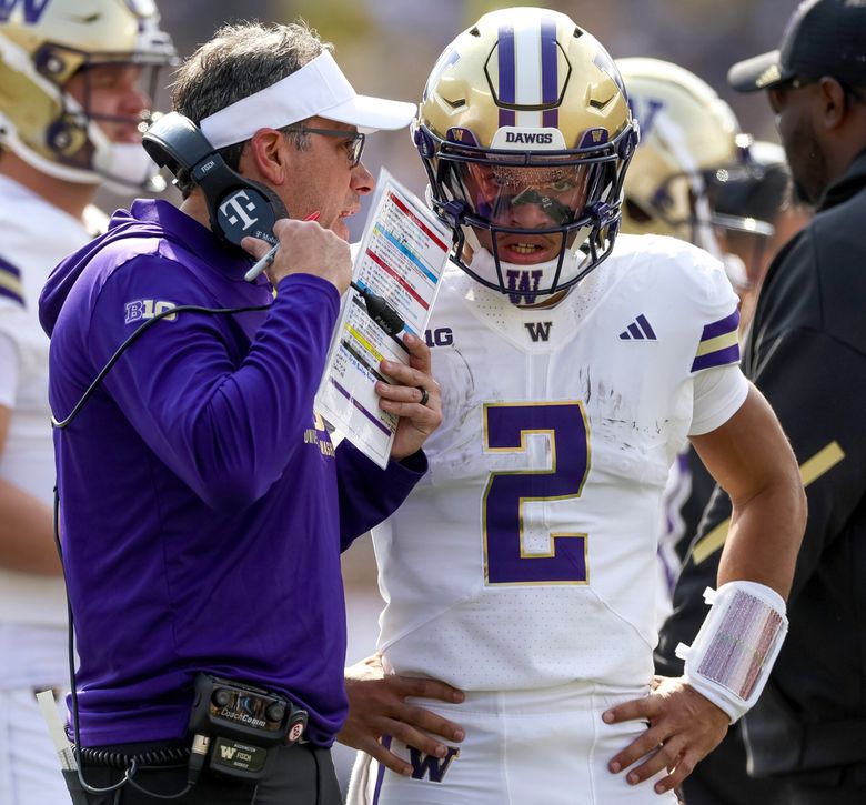Washington head coach Jedd Fisch game-plans a red zone possession with quarterback Demond Williams Jr. (2) during a college football game against the Michigan Wolverines on Saturday, Oct. 18, 2025, in Ann Arbor, Mich. (Nick Wagner / The Seattle Times)