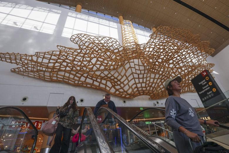 “Boundary” by John Grade pictured at Seattle–Tacoma International Airport on Oct. 16, 2024. It hangs high above travelers in the N Concourse, near Gate N20. (Ivy Ceballo / The Seattle Times)
