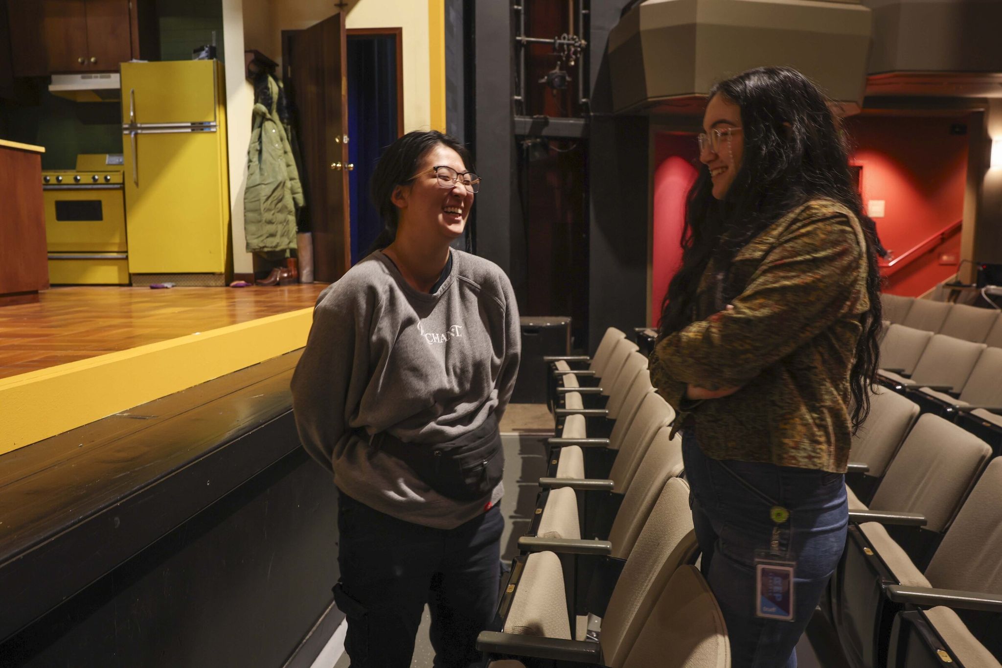 Anna Shikh (left), an apprentice in lighting design, and Jaina Shoda Meyer, an apprentice in directing and artistic programs, during a break in a technical rehearsal at Seattle Rep. Apprenticeships last about 10 months. (Ivy Ceballo / The Seattle Times)