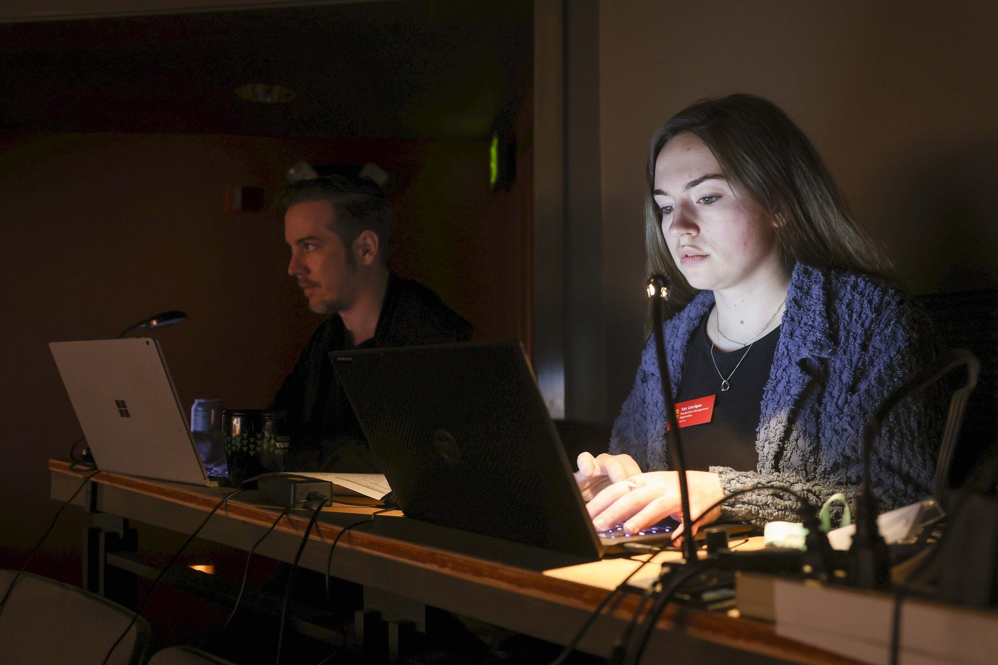 Kat Corrigan (right), an apprentice in production management, works during a technical rehearsal at Seattle Rep. The state-approved apprenticeship programs at the theatre offer guaranteed pay and work hours. (Ivy Ceballo / The Seattle Times)