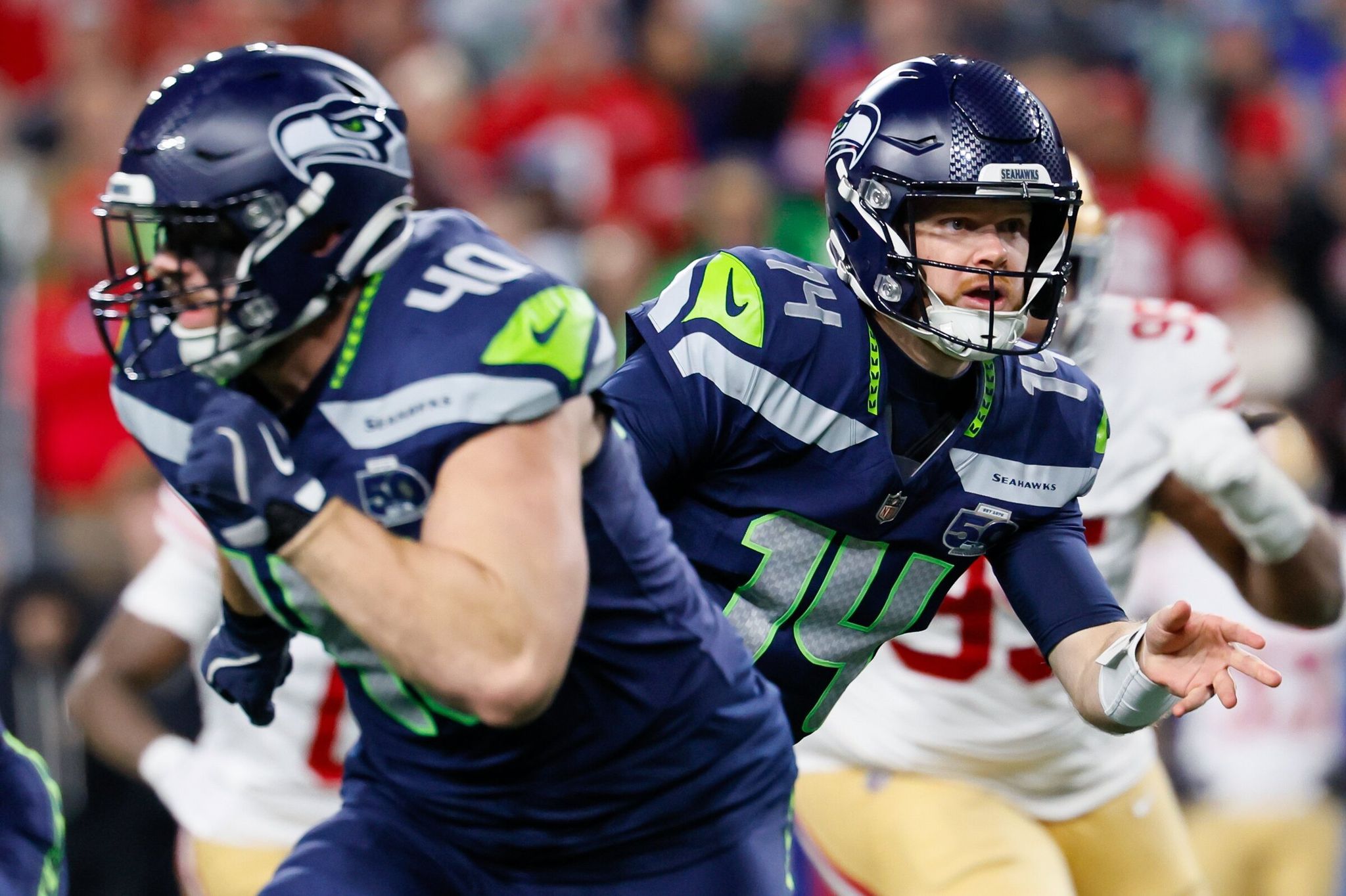 Seahawks quarterback Sam Darnold hands off the ball during the second quarter on Saturday. (Jennifer Buchanan / The Seattle Times)